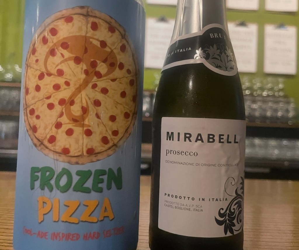 A close up of a fruited seltzer called "Frozen Pizza," and a small bottle of wine, "Mirabell"
